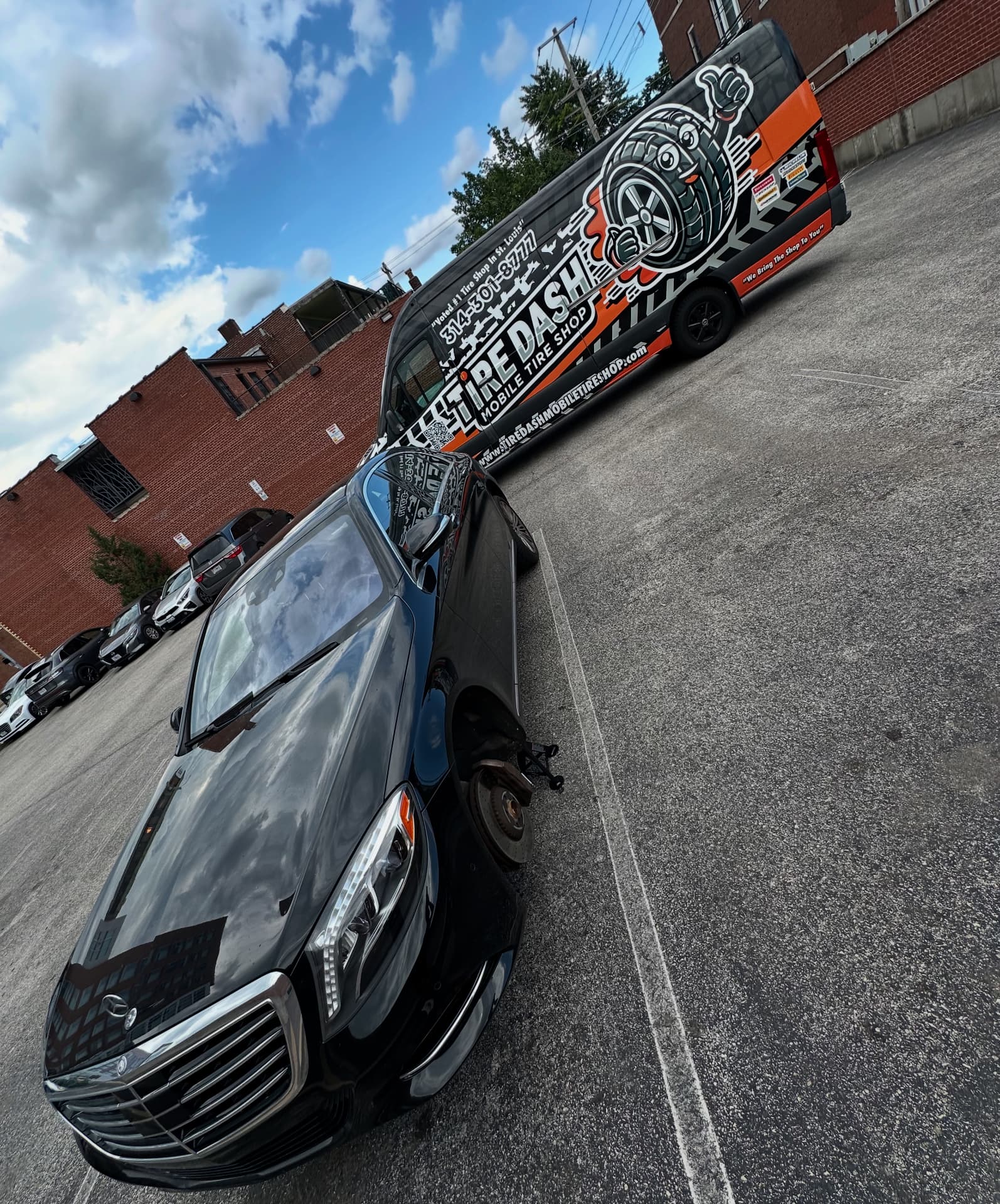 Tire Dash van beside a sedan in a parking lot