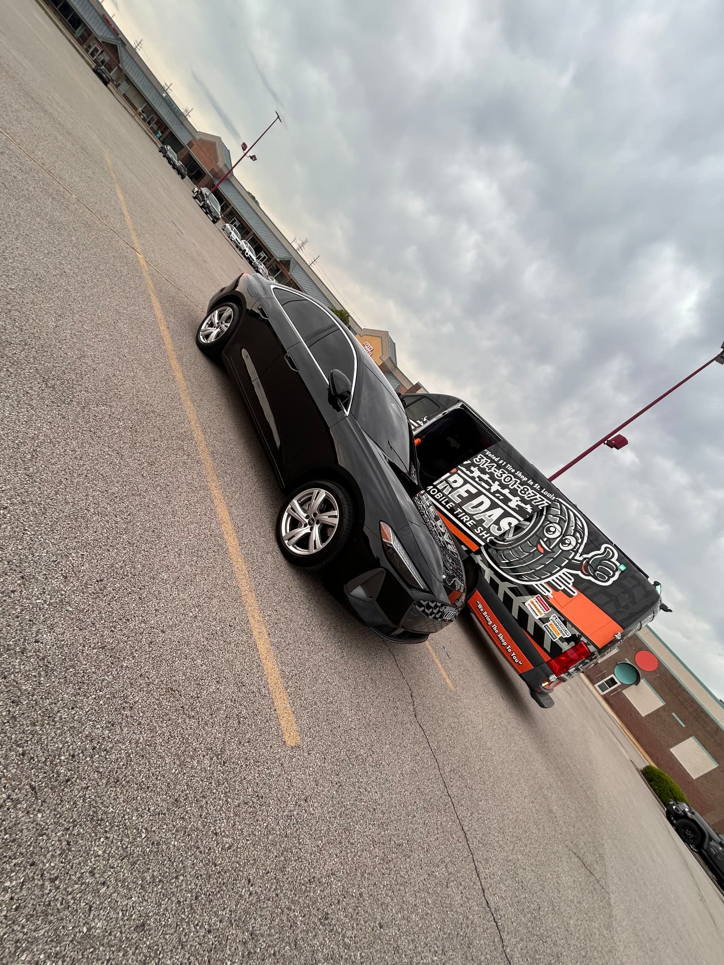 Tire Dash van and a car in a large parking lot